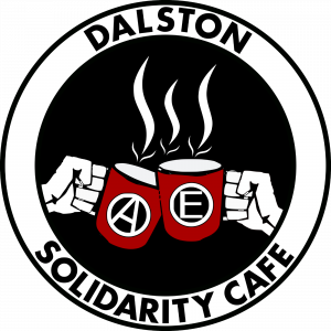 A logo with two closed fists holding red mugs. One of the mugs has the letter “A” on it and the other one the letter “E”. Three arrow shaped fume lines are on top of the mugs. A white circle surrounds the image described. The name “Dalston Solidarity Cafe” is written on this circle in black capital letters.